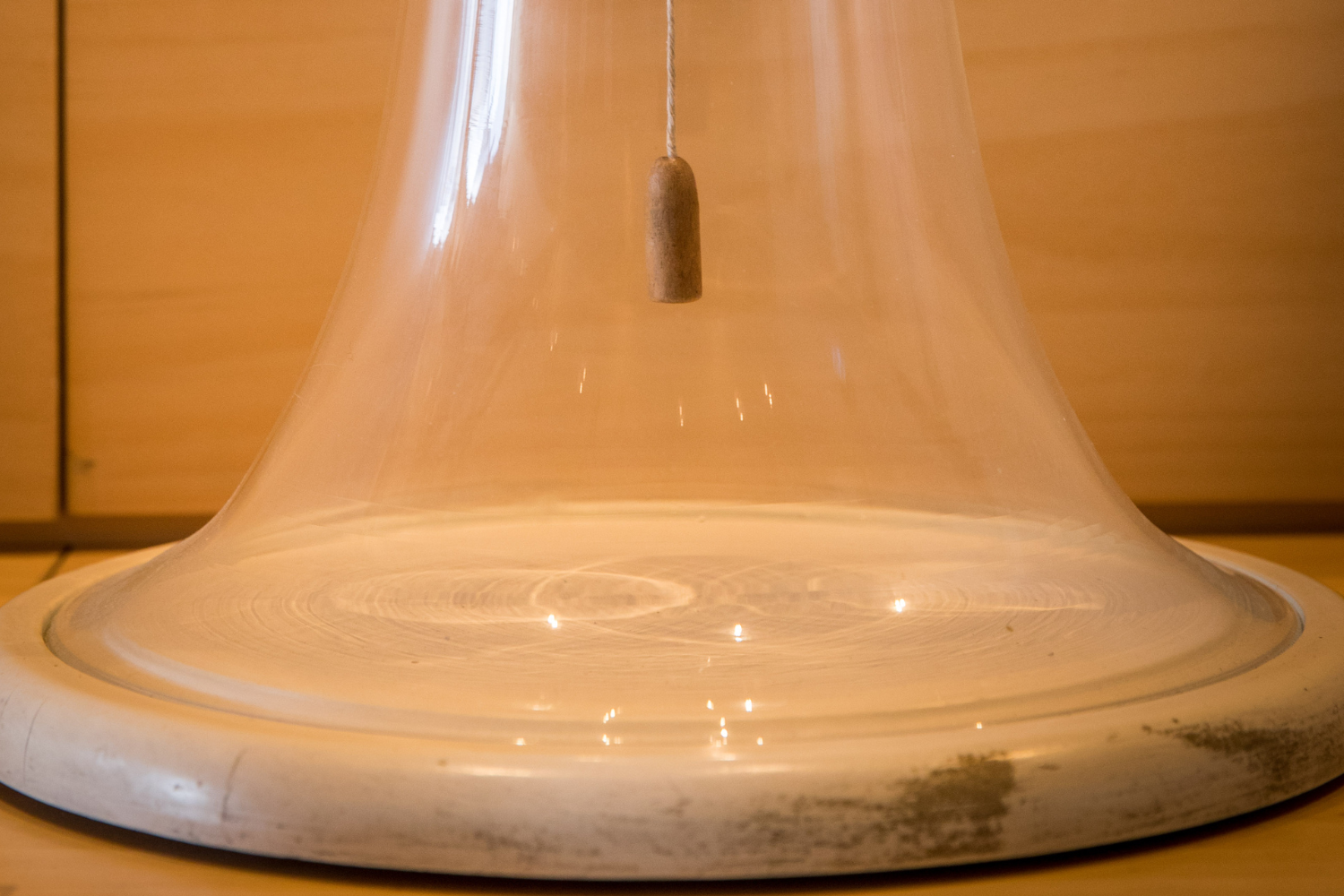 Strumento costituito da una base circolare sormontata da una campana di vetro con all'interno un pendolo.